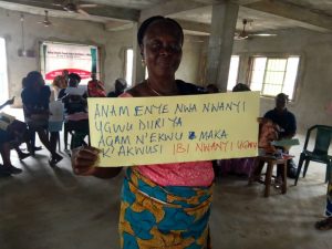 A person standing with a sign about ending FGM/C